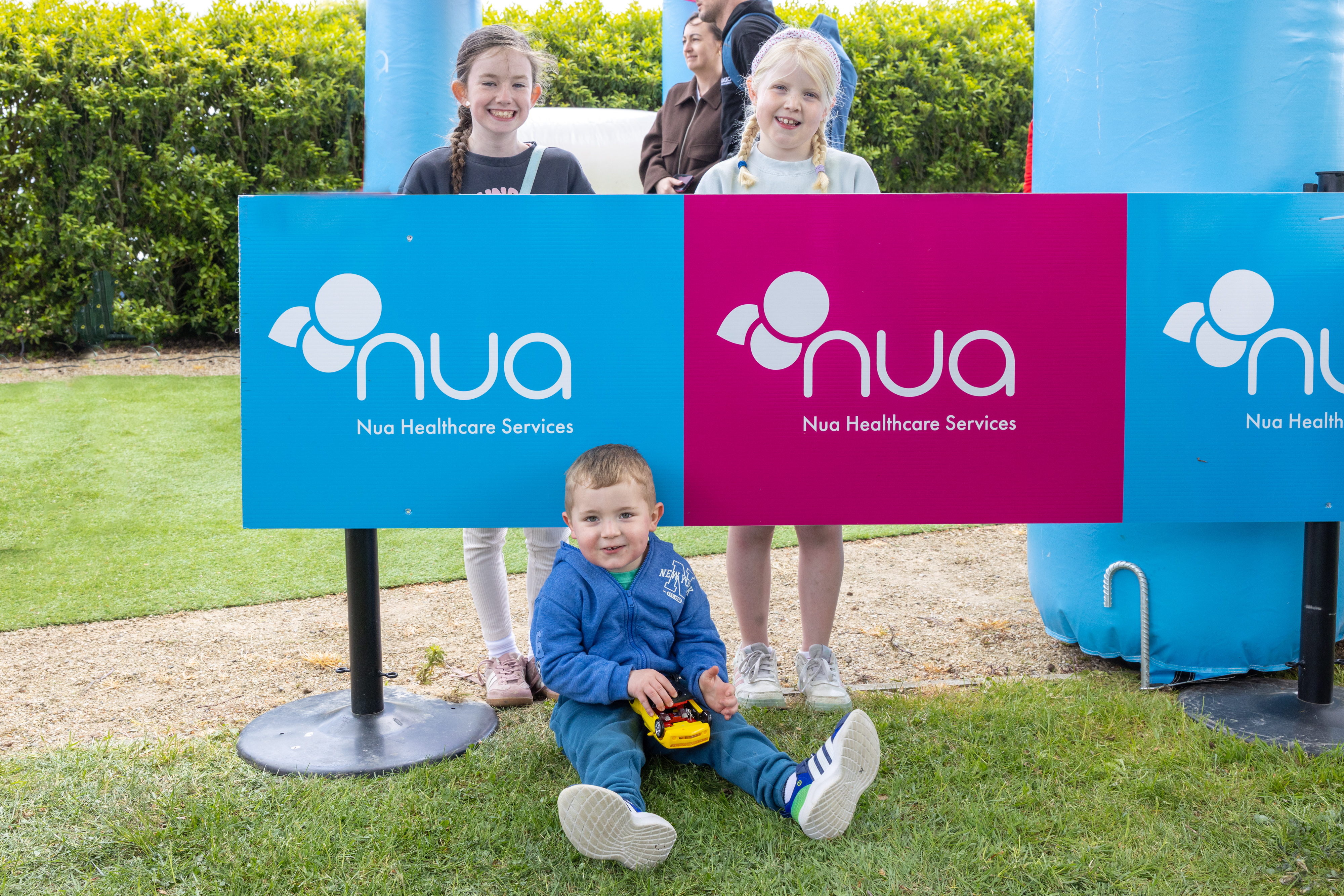 Three children smiling with poster.